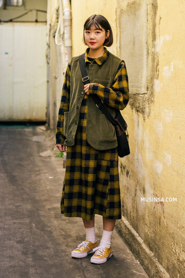 Thêm một gợi ý mix đồ hay ho dành cho những cô nàng yêu phong cách cổ điển: váy kẻ caro mix cùng áo gilet và giày sneaker.