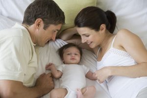 Parents smiling at baby --- Image by © Tom Grill/Tetra Images/Corbis