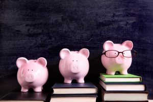 Three piggy banks with blackboard