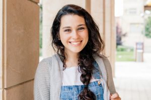 Cute student girl with braid smiling at you