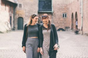 Two beautiful nordic girls visiting old fortress in Oslo, talking and laughing. Lifestyle, tourism and friendship concepts.