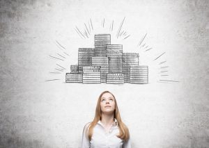Businesswoman looking up, picture of coin piles drawn over her head. Concrete background. Concept of making money.