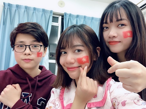 Nhóm Hân và Hiệp dùng son vẽ cờ lên má để cổ vũ đội tuyển. Ảnh: NVCC