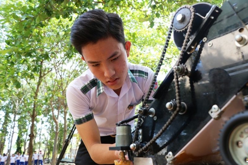Em Nguyễn Hữu Thực đang chỉnh lại máy để chuẩn bị cho máy chạy thử.