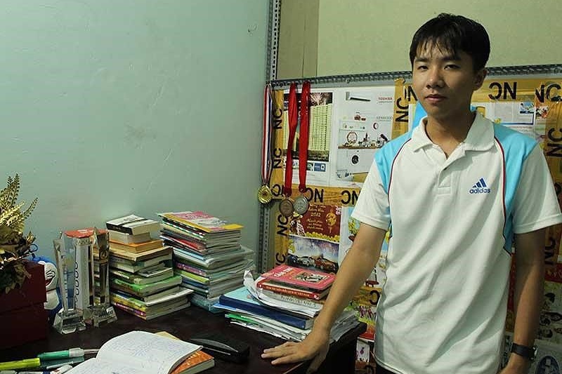 Nguyễn Bá Vinh bên góc học tập nhỏ của mình ở nhà.