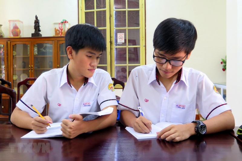Hai anh em Tống Phước Thanh Bình và Tống Phước Thanh An (người đeo kính) trao đổi bài trước giờ lên lớp.