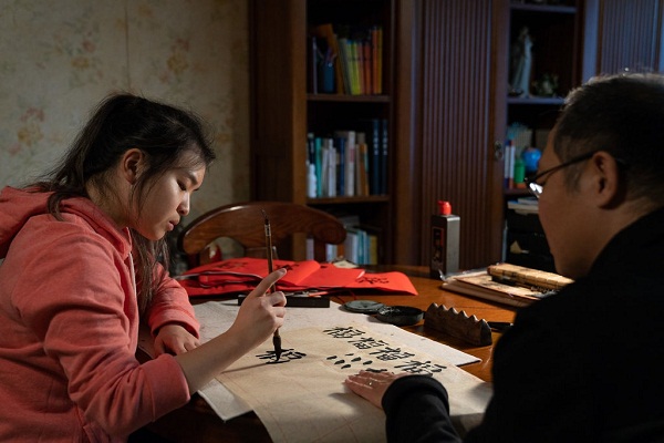 Kathy Song đang học thư pháp cùng với chú của cô ở căn hộ ở Bắc Kinh. (Yan Cong - The New York Times).