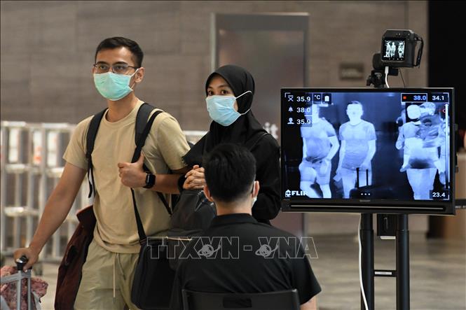 Kiểm tra thân nhiệt phòng lây nhiễm COVID-19 tại sân bay quốc tế Changi, Singapore. Ảnh: AFP/TTXVN
