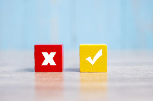 Wood cubes block with Wrong and Right symbol on table background