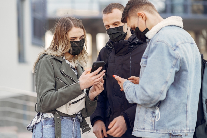 People in a masks stands on the street