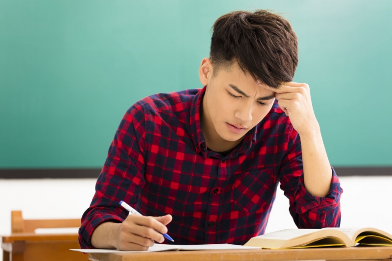 52000319 - stressed student  studying for exam in classroom