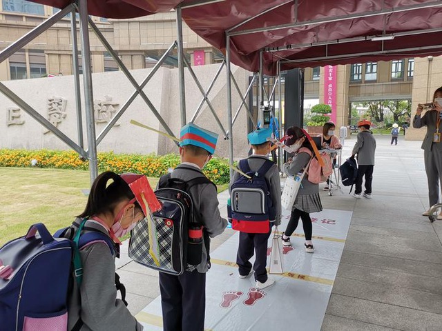 Học sinh trường Tiểu học Yangzheng (Chiết Giang, Trung Quốc) đội mũ trong ngày đầu tiên trở lại trường (26/4).