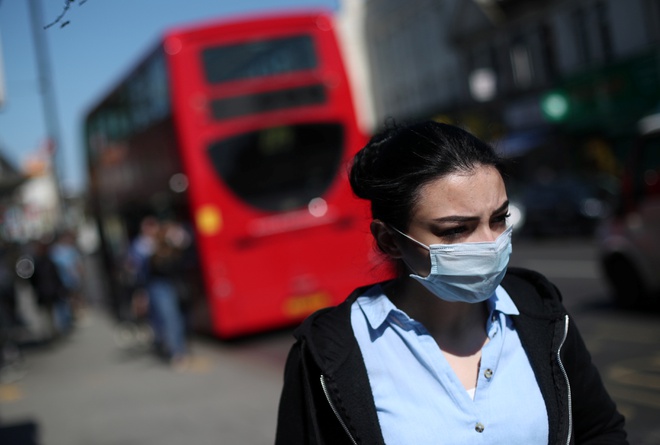 Người đeo khẩu trang tại London hôm 14/4. Ảnh: Reuters.