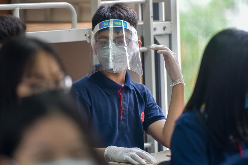 Một học sinh trường Marrie Cuire cẩn thận đeo tấm chắn giọt bắn trong ngày đầu tới trường