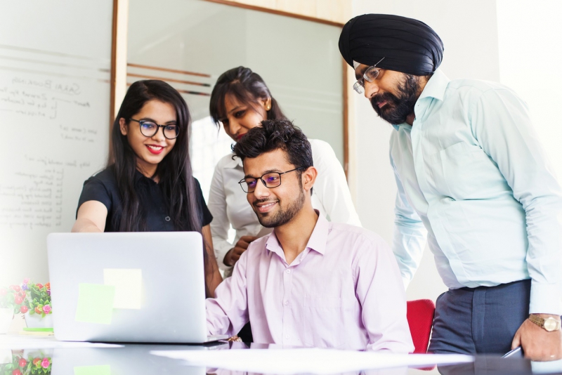 Indian team working together and looking on a screen of laptop