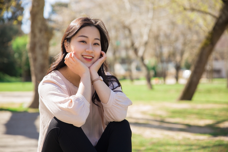 Outdoor portrait of positive smiling Asian student girl