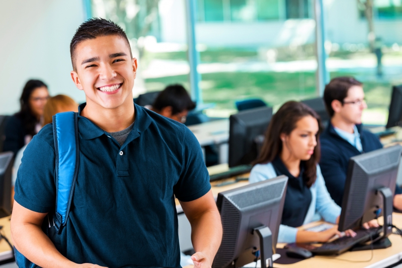 Friendly private high school student smiling in modern computer lab