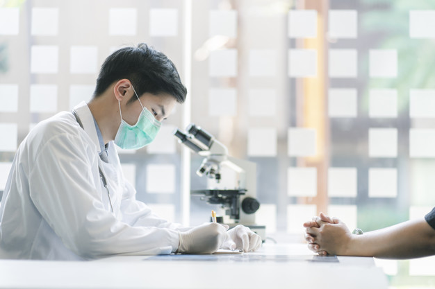 Doctor and patient at medical examination in hospital office. Medicine and healthcare concept.