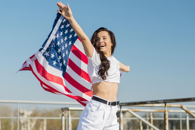 brunette-woman-holding-big-usa-flag_23-2148534423