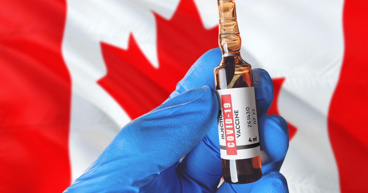 Canada flag with Coronavirus Covid-19 concept. Doctor with blue protection medical gloves holds a vaccine bottle. coronavirus covid 19 vaccine research.
