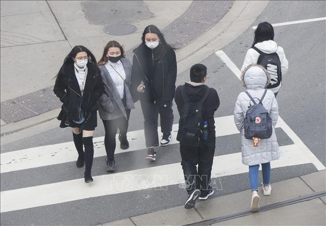 Người dân đeo khẩu trang nhằm ngăn chặn sự lây lan của dịch COVID-19 tại Toronto, Canada ngày 11/3/2020. Ảnh: THX/TTXVN