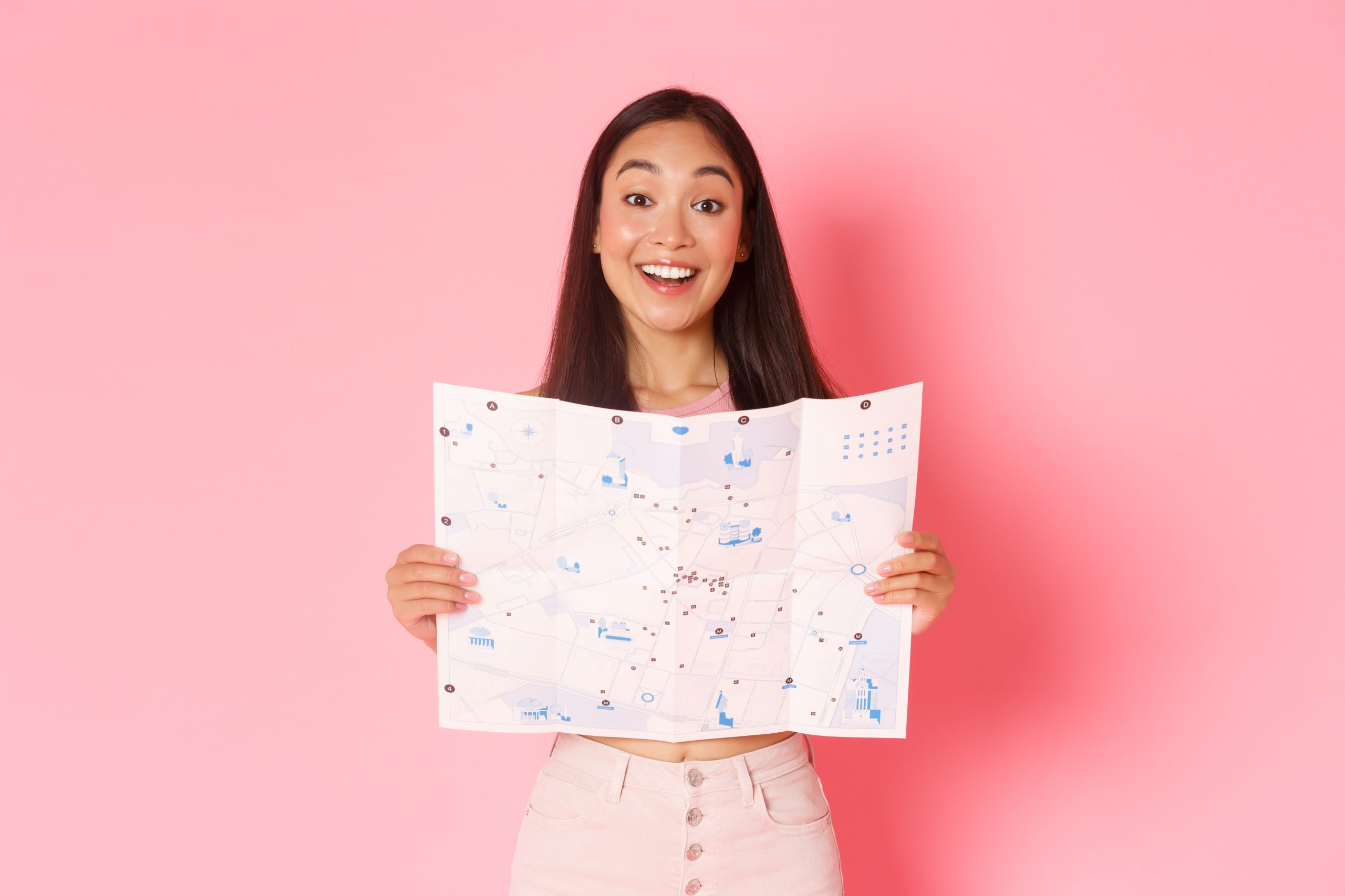 travelling-lifestyle-tourism-concept-cheerful-attractive-asian-girl-tourist-explore-new-city-visiting-museums-showing-map-city-with-sightseeings-smiling-upbeat-pink-background-scaled - Copy